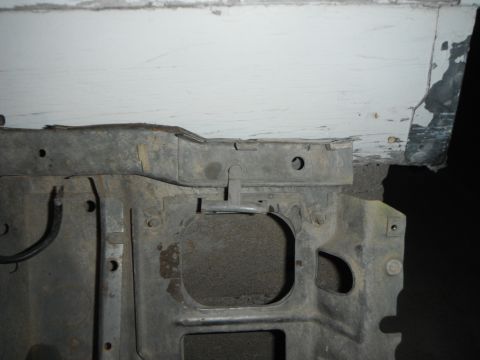 1995 Ford F-150 - Close-up of a vehicle's metal frame structure, showing mounting points and weathered surfaces.