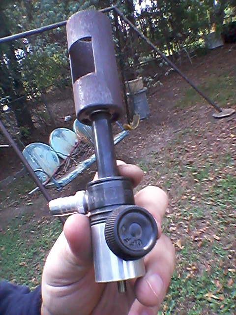 1996 Ford Bronco - A close-up of a gas regulator part is held in a hand outdoors, with a swing set in the background.
