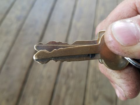 1988 Ford Bronco - A close-up shows two car keys held by a hand against a wooden background.