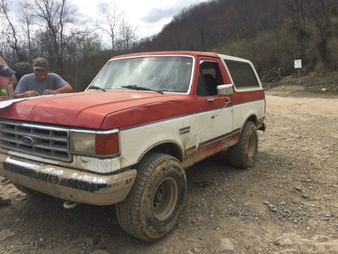 1987 Ford Bronco - This 1987 Ford Bronco has a two-tone red and white paint scheme and appears to be off-road.