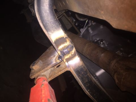 1982 Ford Bronco - Close-up view of a modified vehicle frame with visible welding and supporting jack.