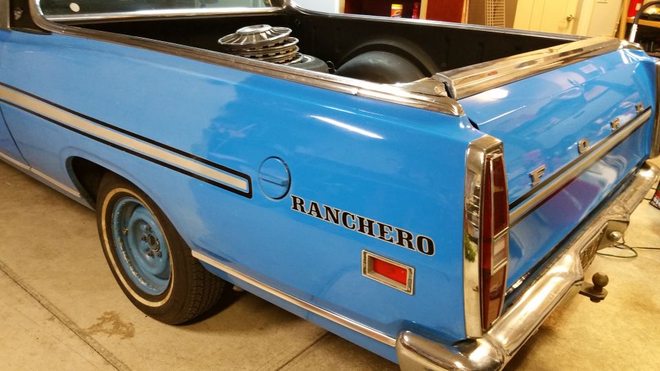 Blue 1971 Ford Ranchero rear quarter panel with 'RANCHERO' text and chrome trim. Hubcaps are in the bed