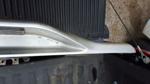 1994 Ford Bronco - A close-up view of a silver running board, likely removed from a vehicle, is shown resting on a truck bed.