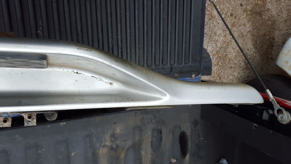 Silver running board with some scuffs, resting on a truck bed