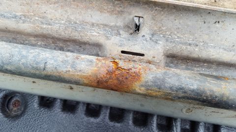 1994 Ford Bronco - Close-up of a corroded vehicle running board, showing signs of significant rust and wear.