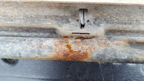 1994 Ford Bronco - Close-up of a heavily rusted running board bracket, showing significant corrosion and a Supermotors logo in the corner.