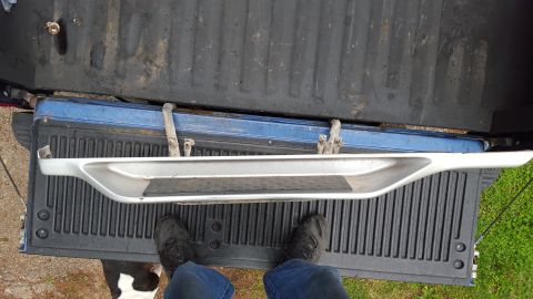 1994 Ford Bronco - Running board placed inside a pickup truck bed, with a person standing nearby.