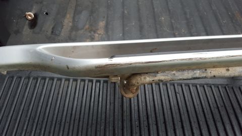 1994 Ford Bronco - Close-up of a silver running board, showing wear and a metal hook underneath.