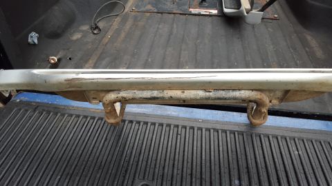 1994 Ford Bronco - Close-up of a rusty running board bracket in a truck bed.