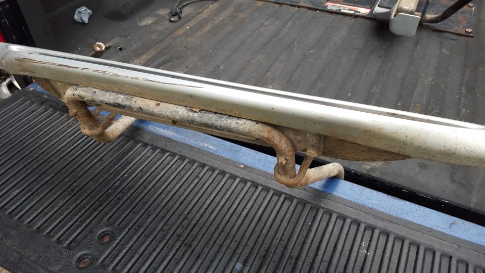 running board with rusty brackets, sitting on a ribbed surface