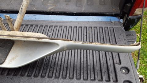 1994 Ford Bronco - A gray running board with a metal support is shown resting on a truck bed.