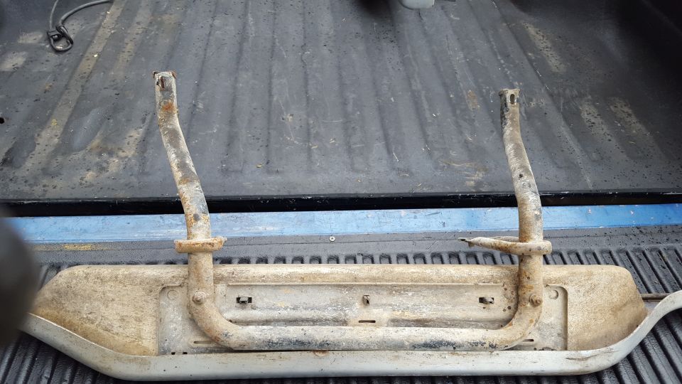 Pair of rusty running boards resting in a truck bed
