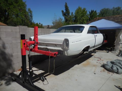 1966 Ford Fairlane - White 1966 Ford Fairlane coupe is elevated on a car lift in an outdoor setting.