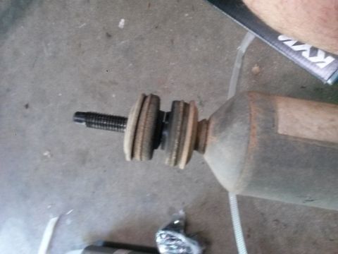 1996 Ford Bronco - Close-up of a shock absorber part, showing the threaded mounting stud and bushings.
