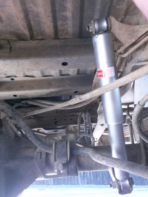 1996 Ford Bronco - A close-up view of the rear suspension system of a vehicle, focusing on the shock absorber and surrounding components.