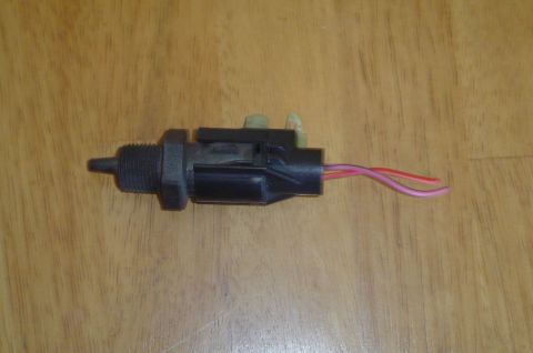 1993 Ford Bronco - A close-up view of an electrical connector with attached wires, placed on a wooden background.