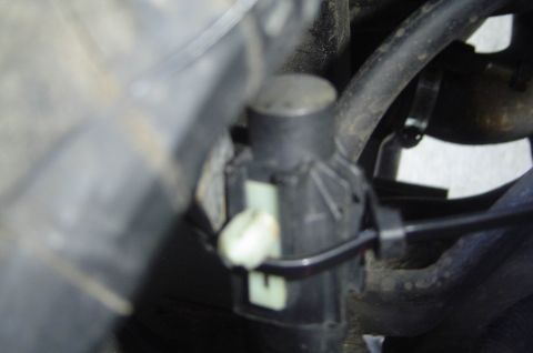 1993 Ford Bronco - Close-up view of an engine component, likely a sensor or actuator, with a black plastic housing and a white electrical connector.