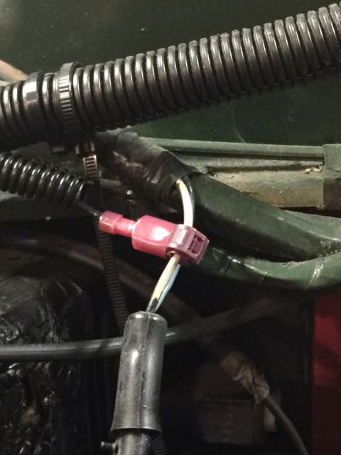 1978 Ford Bronco - Close-up view of automotive wiring with a red connector attached to white and yellow wires.