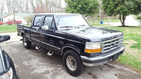 1994 Ford Bronco - This black Ford F-250 Super Duty pickup truck is parked in a driveway.