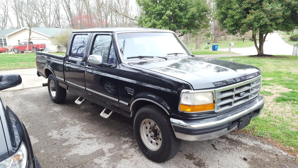 Black 1995 Ford F-250 Super Duty pickup truck parked outside