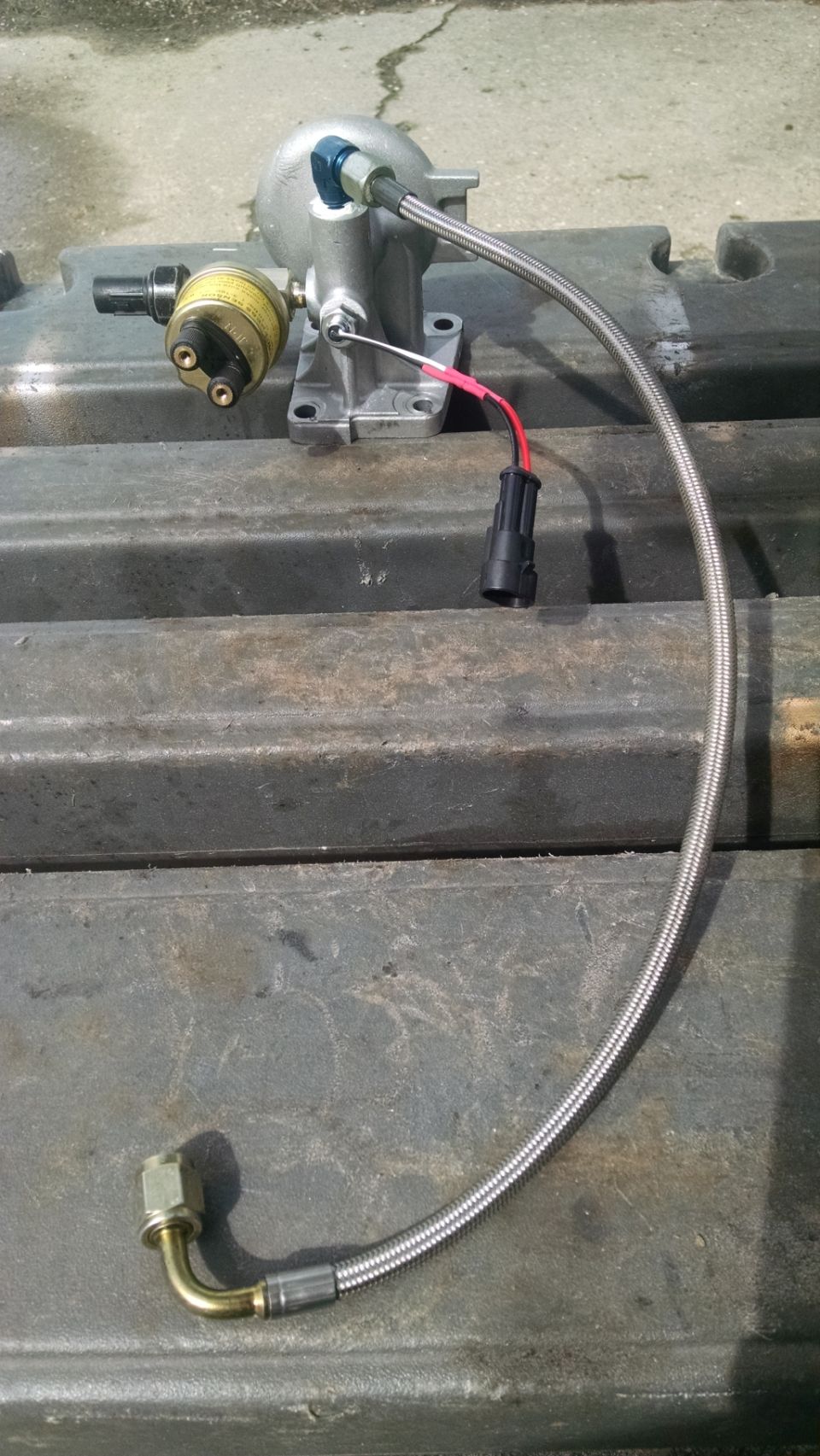 Automotive fuel pressure regulator with braided fuel line and electrical connector