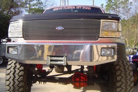 1993 Ford Bronco - Front view of a lifted Ford truck with a prominent grille and bumper, modified for off-road use.