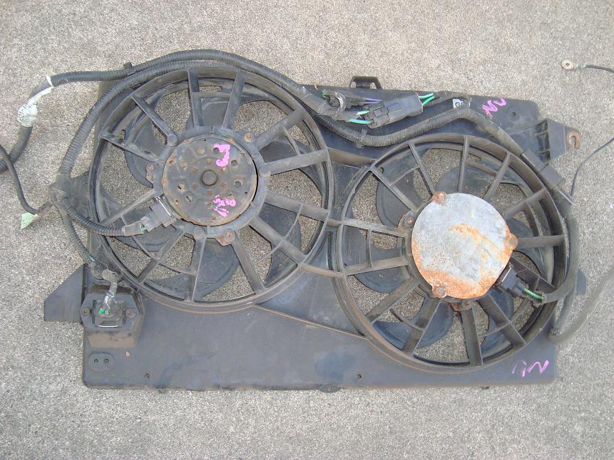 Dual electric radiator fan assembly with wiring harness lying on concrete pavement
