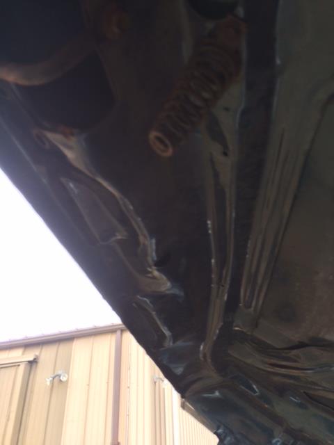 1979 Ford F-150 - The underside of a vehicle's hood is shown, with a spring mechanism visible.