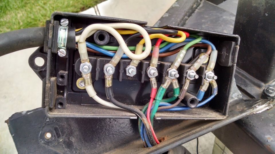 Wiring harness junction box with multiple colored wires connected to terminals