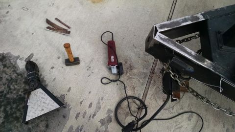 2016 Ford F-250 - Tools and parts laid out on a concrete surface next to a trailer frame.