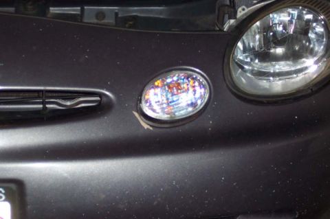 1996 Ford Taurus - Close-up of the front end of a 1996 Ford Taurus, showing the headlight and fog light assembly.