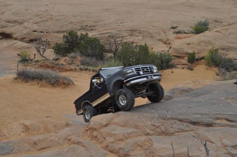 1991 Ford Bronco - Black 1992 Ford Bronco navigating a rocky off-road course in a desert landscape.