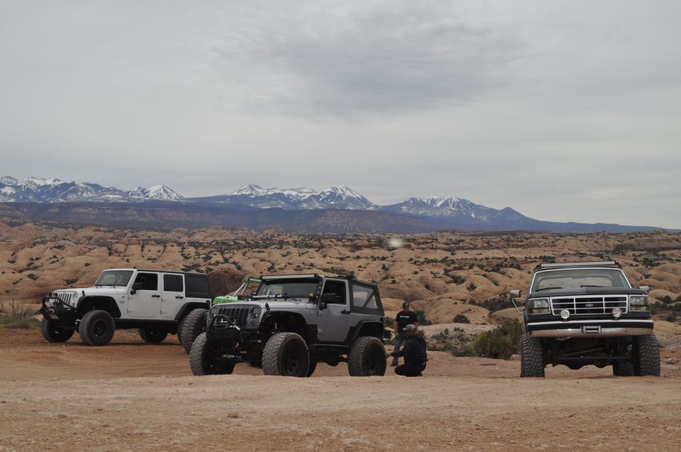 1991 Ford Bronco front view in desert with two Jeeps