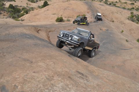 1991 Ford Bronco - A lifted 1992 Ford F-150 navigates a steep, rocky trail in Moab, Utah, with other off-road vehicles following behind it tow.