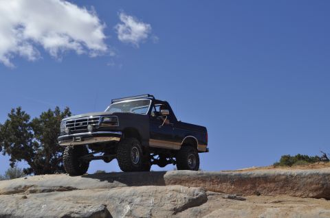 1991 Ford Bronco - This lifted 1991 Ford Bronco navigates a rocky trail under a clear blue sky.