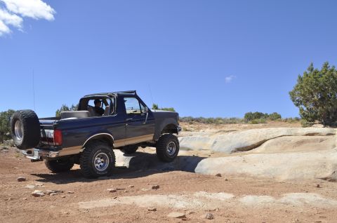 1991 Ford Bronco - This 1991 Ford Bronco navigates a rocky desert trail under a clear blue sky.