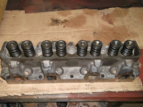 1964 Ford Galaxie - Close-up of an engine cylinder head, showing valve springs and stamped markings.