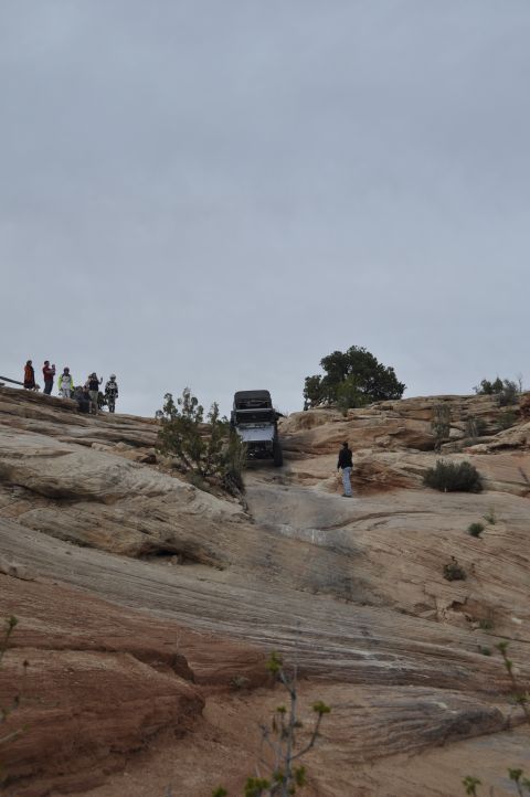 1991 Ford Bronco - Two off-road vehicles navigate a steep, rocky incline under an overcast sky.