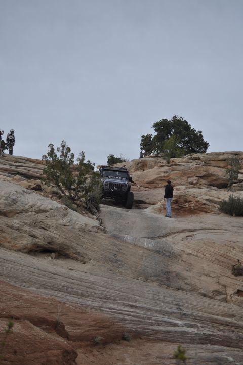 1991 Ford Bronco - A Jeep navigates a challenging off-road trail in a desert landscape.