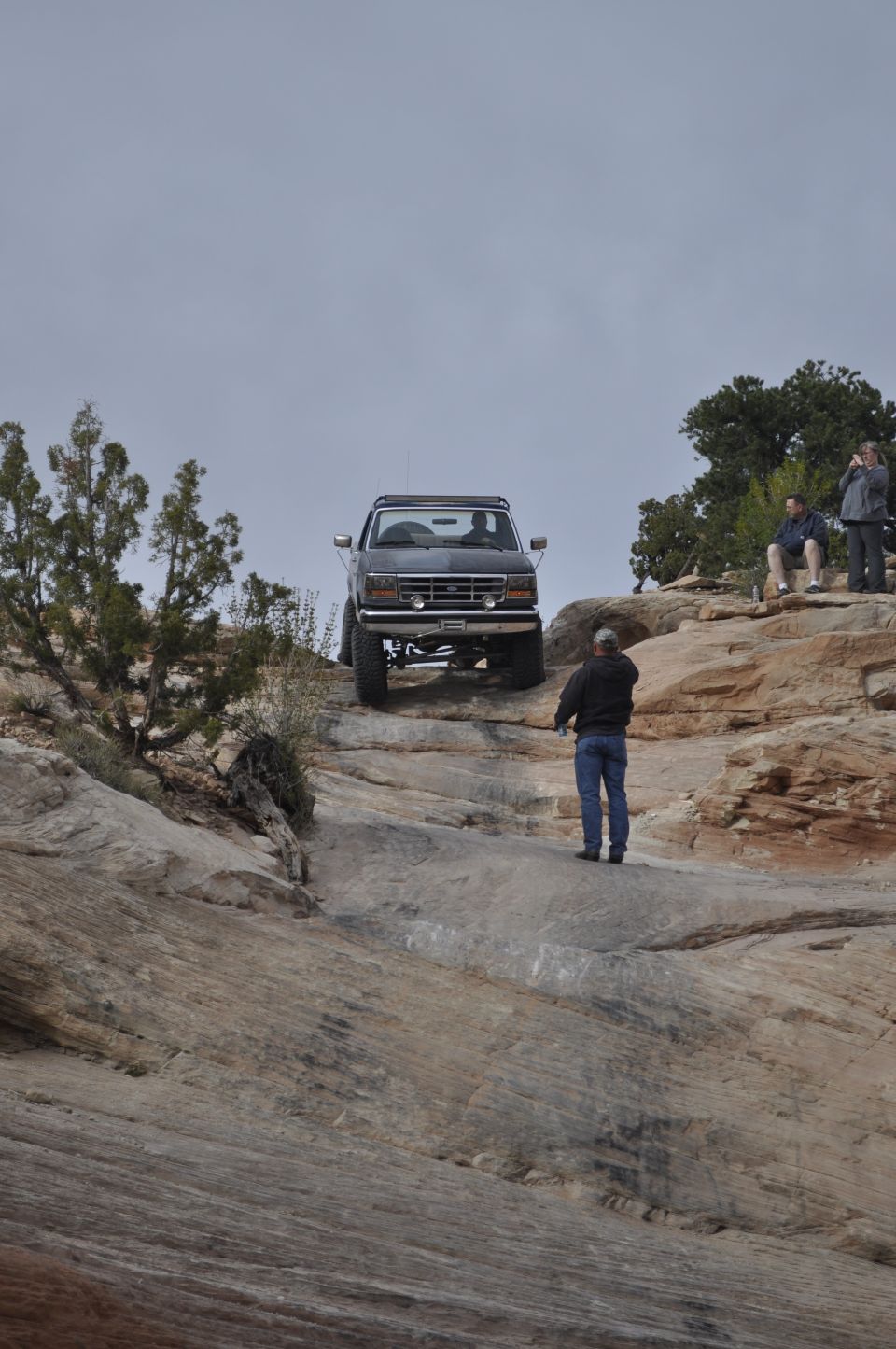Dark gray Ford Bronco climbing a rocky incline, front view