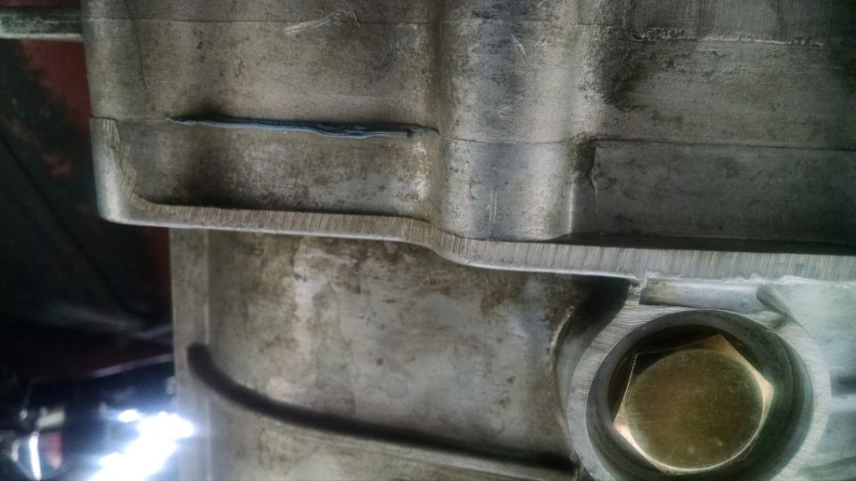 Close-up of a metal differential housing with a hexagonal bolt head visible in a circular opening