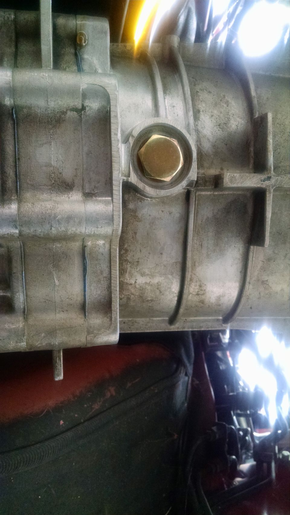 Transmission housing with a hexagonal plug, showing some grime and wear