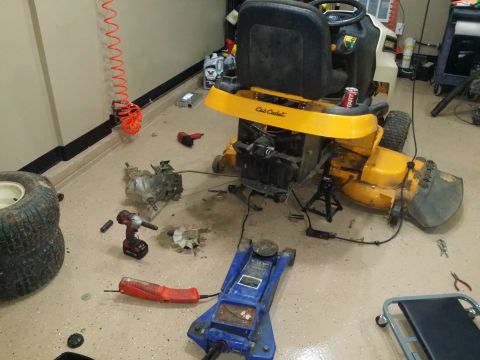 2007 Subaru Impreza - Lawn tractor undergoing repairs in a garage, surrounded by tools and removed components.