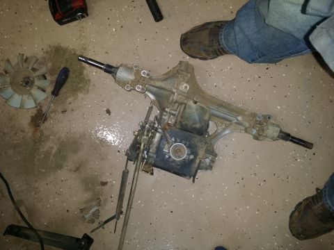 2007 Subaru Impreza - A disassembled lawn mower transaxle sits on a garage floor, ready for repair or replacement.