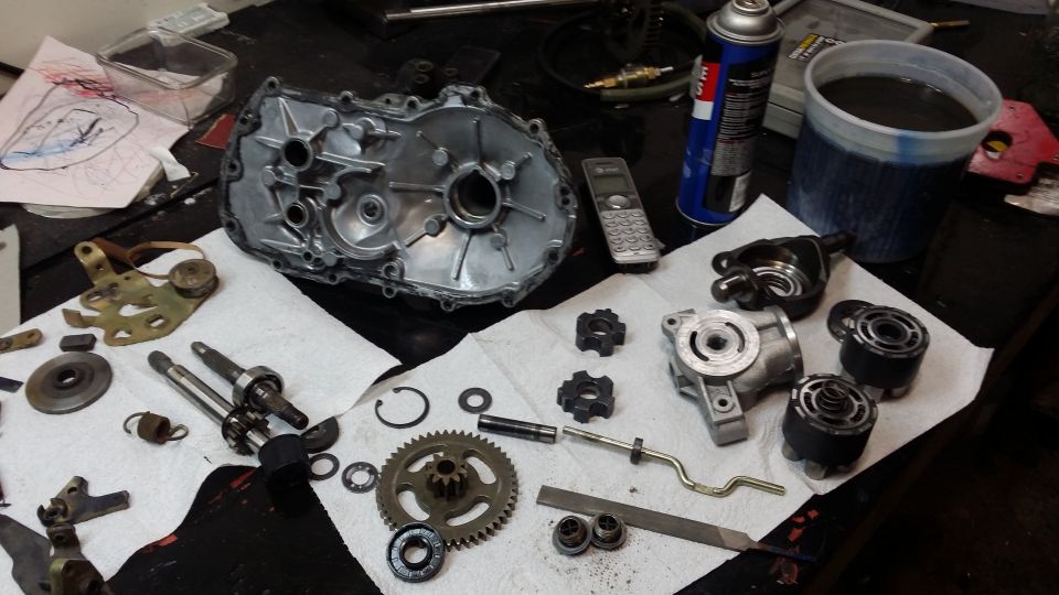 Engine parts laid out on a workbench with a Supermotors.net watermark