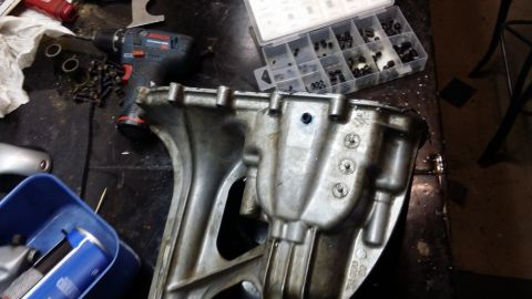 2007 Subaru Impreza - A close-up view of an engine oil pan with various tools and fasteners scattered around it.