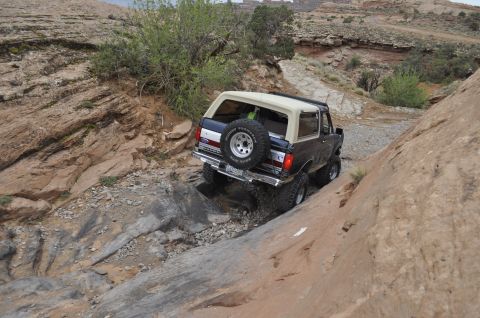 1991 Ford Bronco - A 1991 Ford Bronco tackles a challenging rocky incline on an off-road trail.