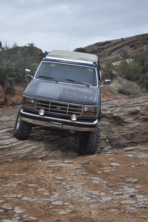 1991 Ford Bronco - This Ford Bronco navigates a challenging rocky trail, its front grille indicating a 1992 model year.
