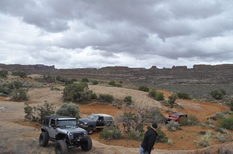 1991 Ford Bronco - Several off-road vehicles, including a 1991 Ford Bronco, navigate a desert trail.