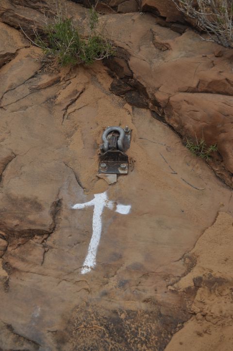 1991 Ford Bronco - A rock face displays a metal anchor and a white painted symbol, possibly a trail marker.